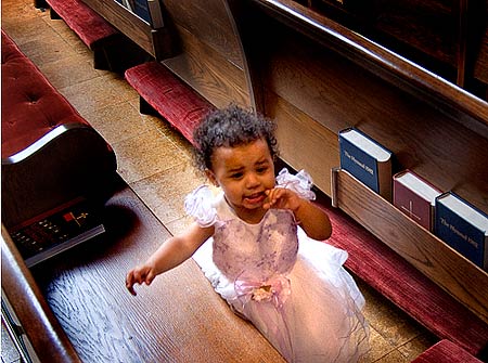 Photo of a little girl lost in the pews at a church, crying, searching for Mother.