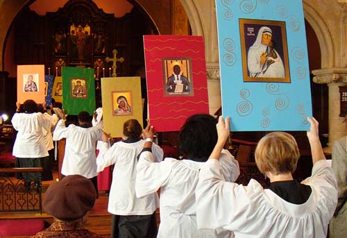 photo: icons in procession, including Mother Teresa, Martin Luther King, Jr., and Mahatma Ganhdi