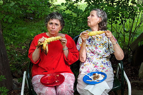 Two women eating corn