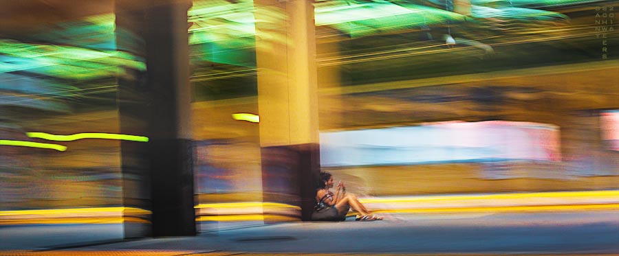 Woman sitting at train station, New Jersey Transit