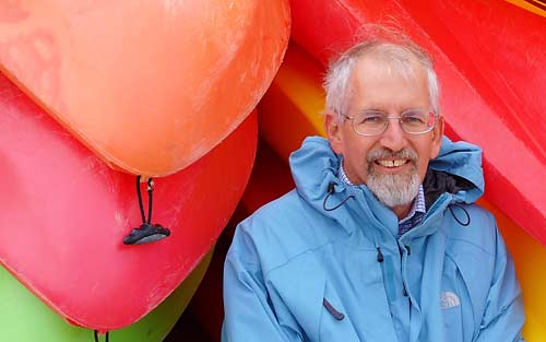 Photo of Danny Schweers with colorful kayaks in background